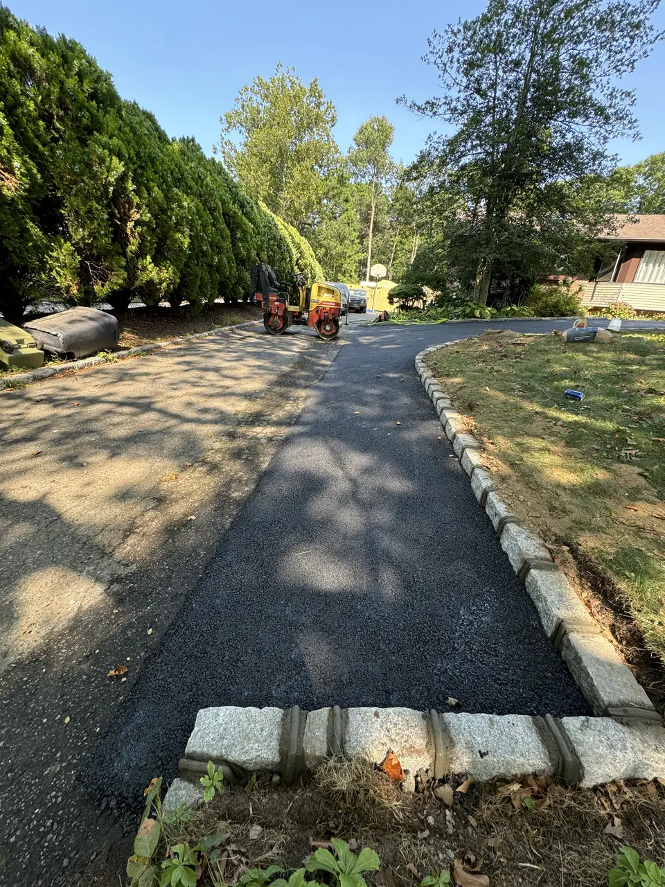 New asphalt driveway edged with Belgian block curbing