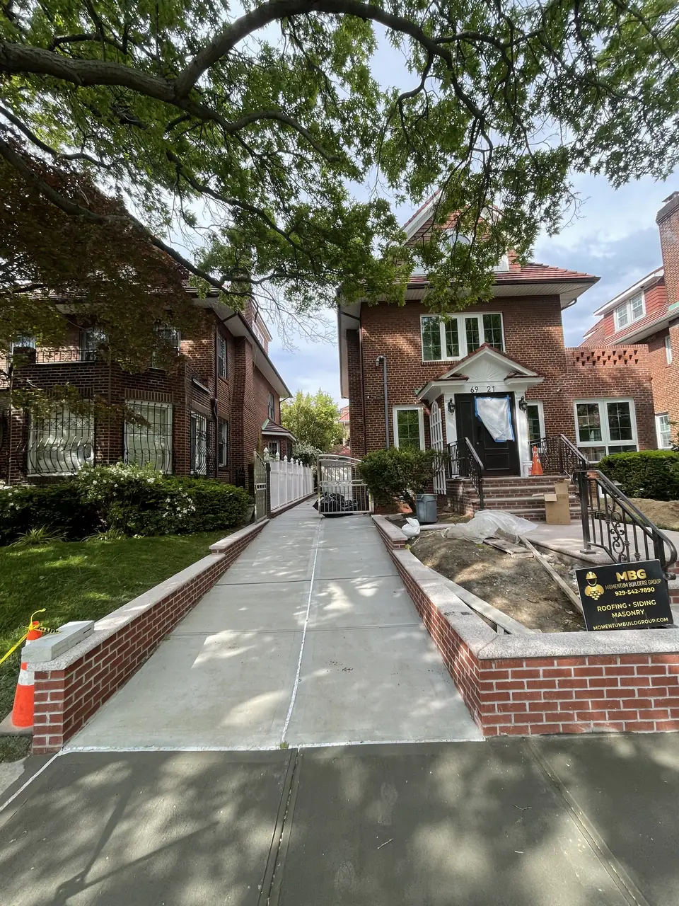 Brick walls with caps lining a new concrete walkway