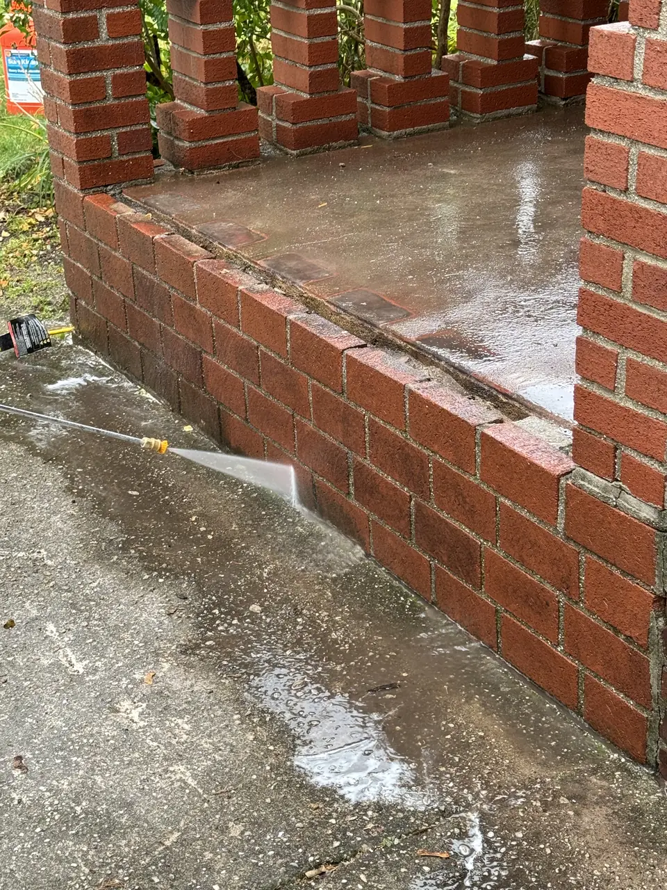 Brick porch walls being washed after repair