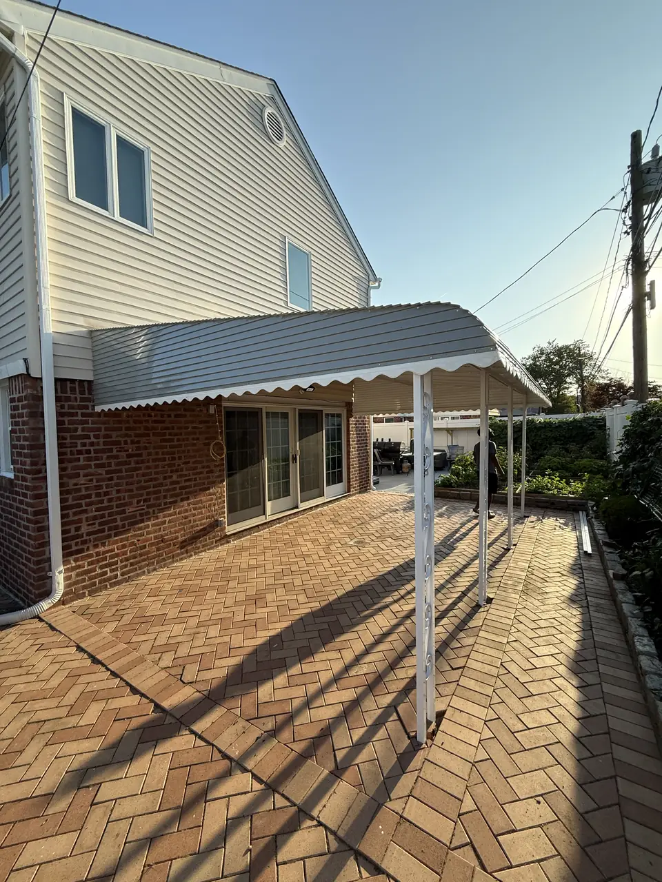 Red herringbone brick paver patio beside a house