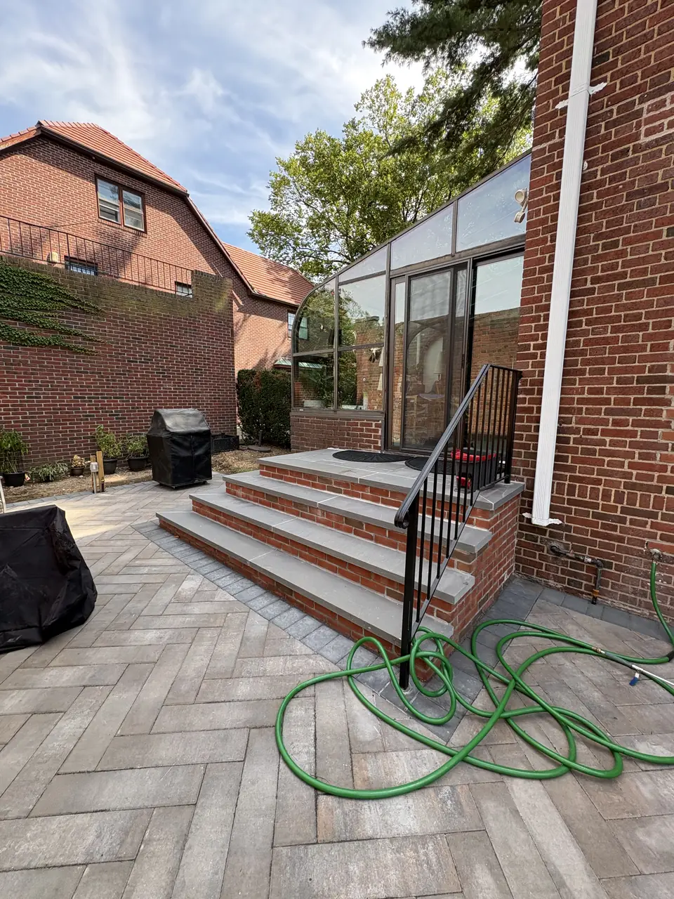 Paver patio and steps alongside a brick house