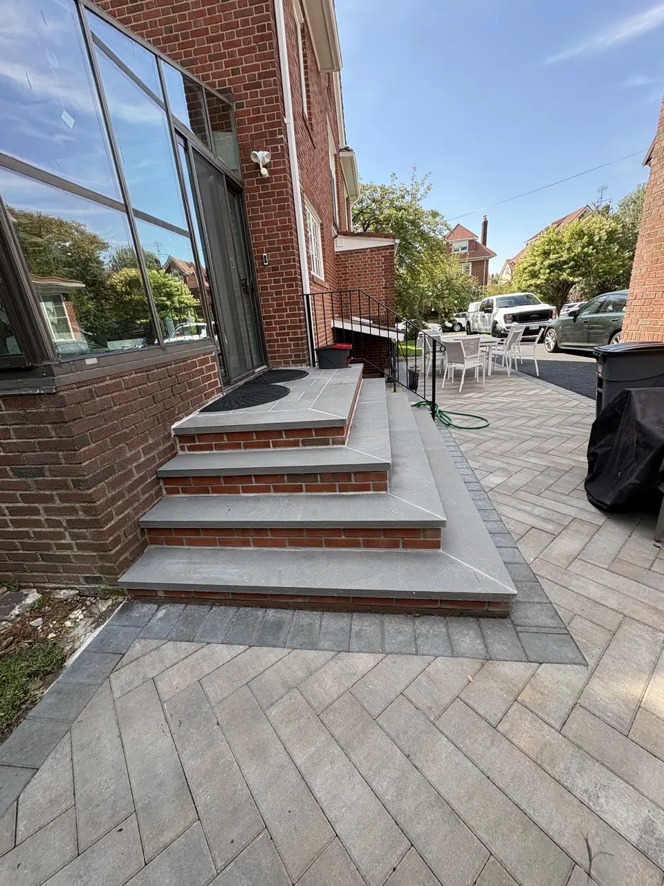 Paver steps with dark border leading up to a glass sunroom