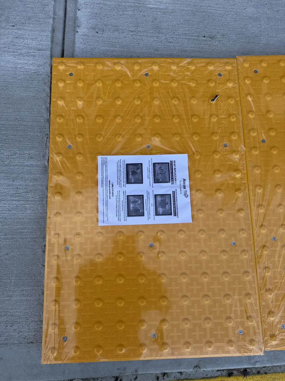 Yellow tactile warning pad set into a new curb ramp